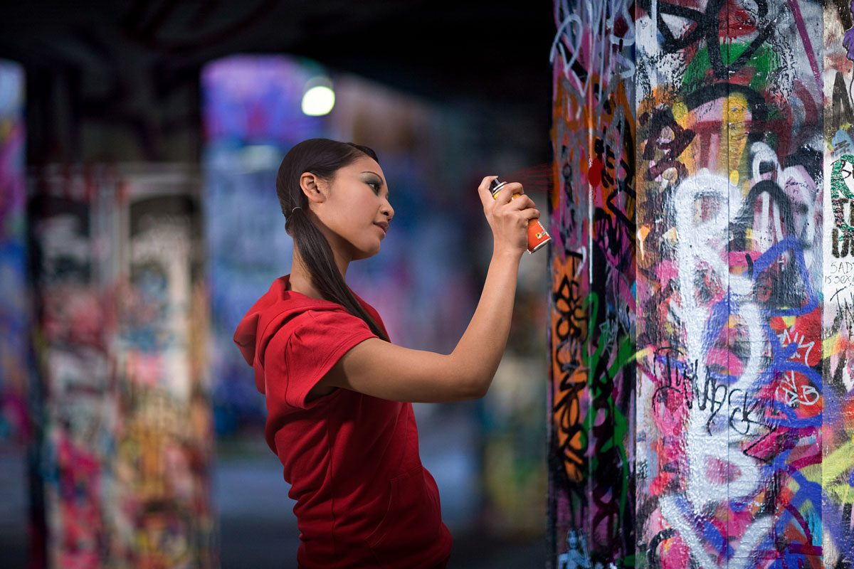 a-young-woman-spraying-graffiti-min